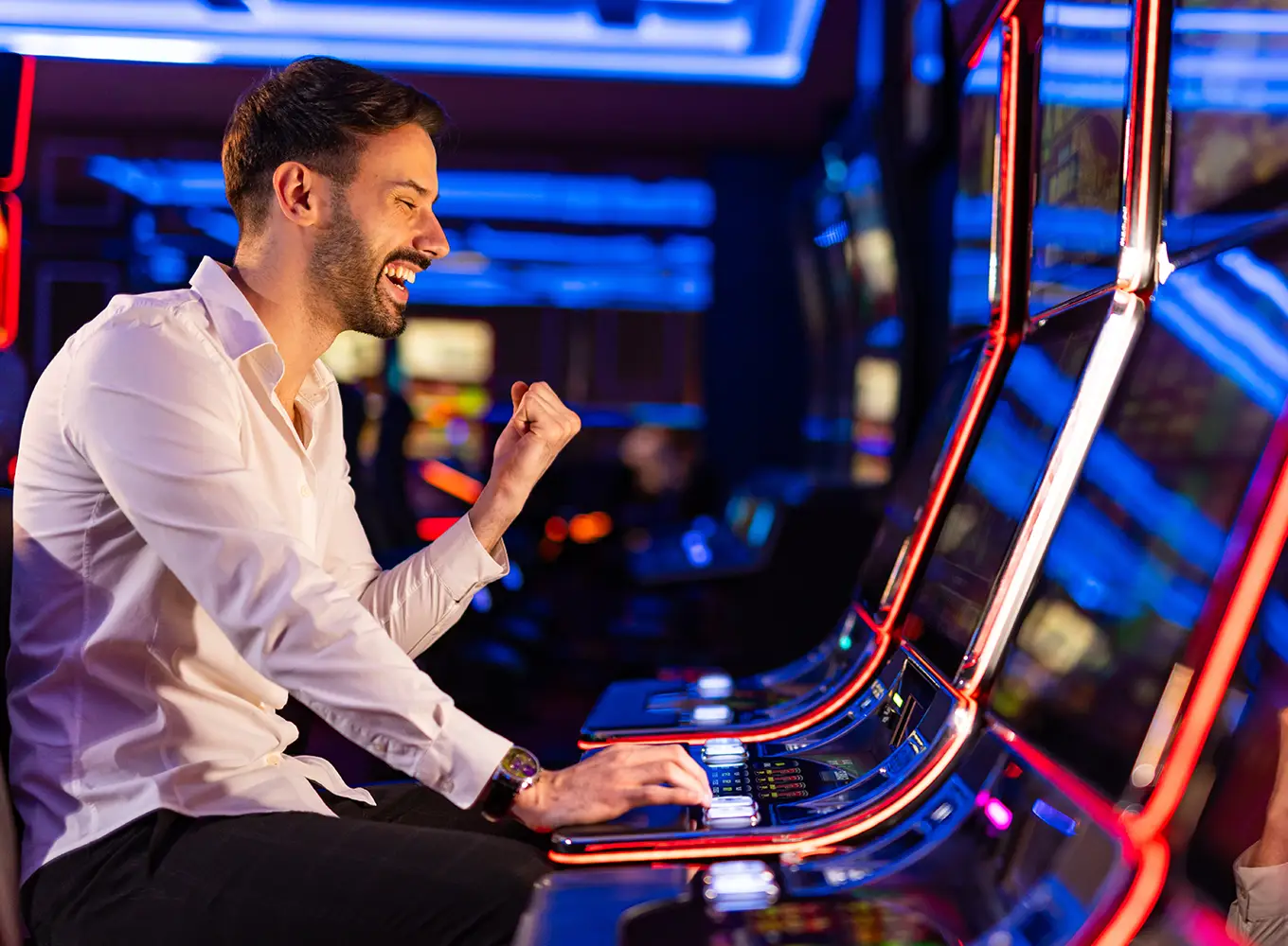man gambling at a slot machine and is happy he is in control and is winning