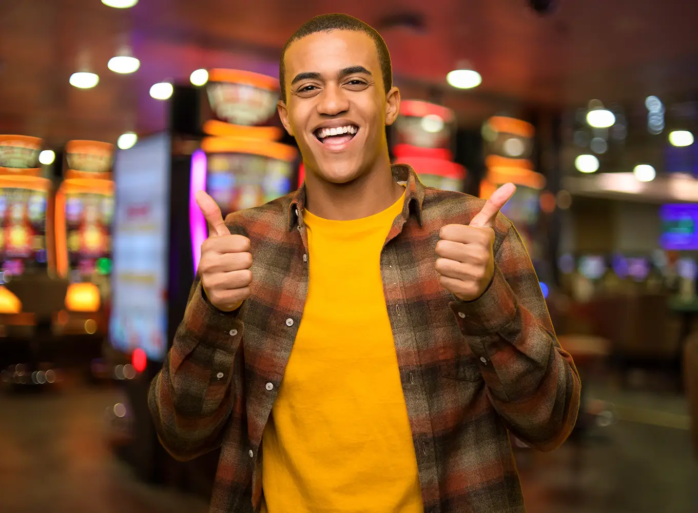 young man with his thumbs up in a casino setting